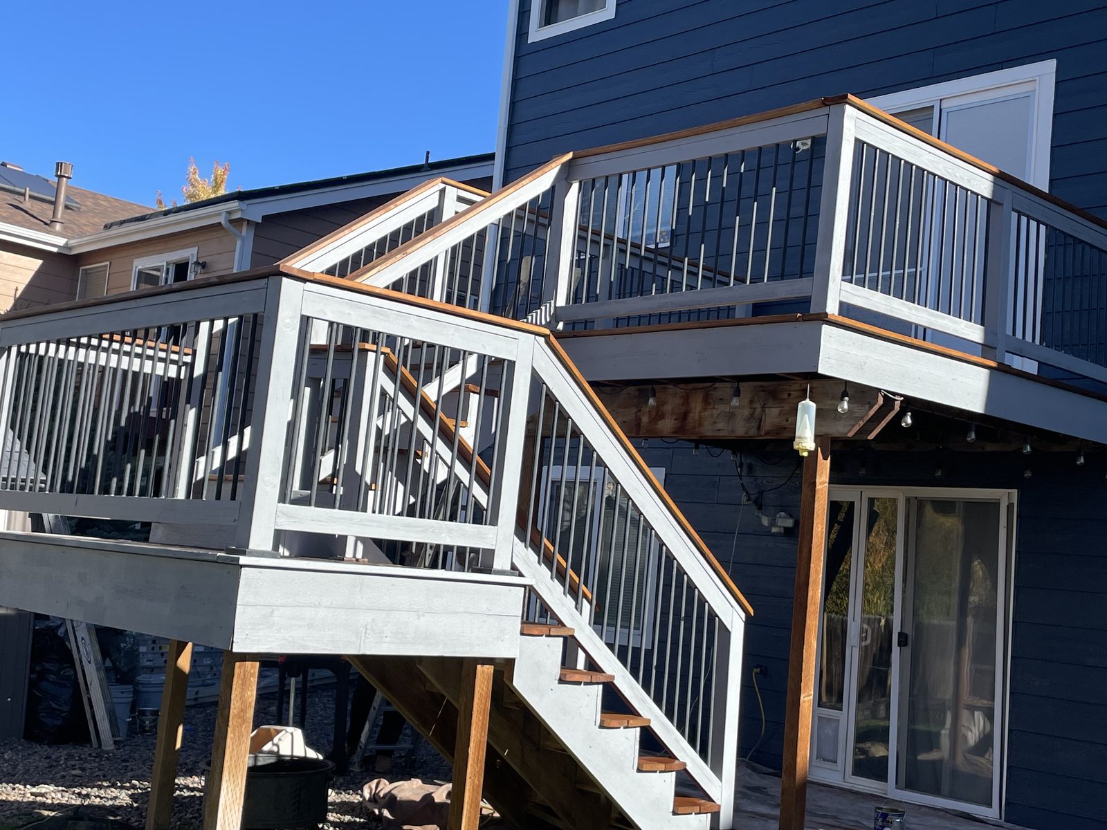 Two-level deck freshly restained with gray rails and cedar treads